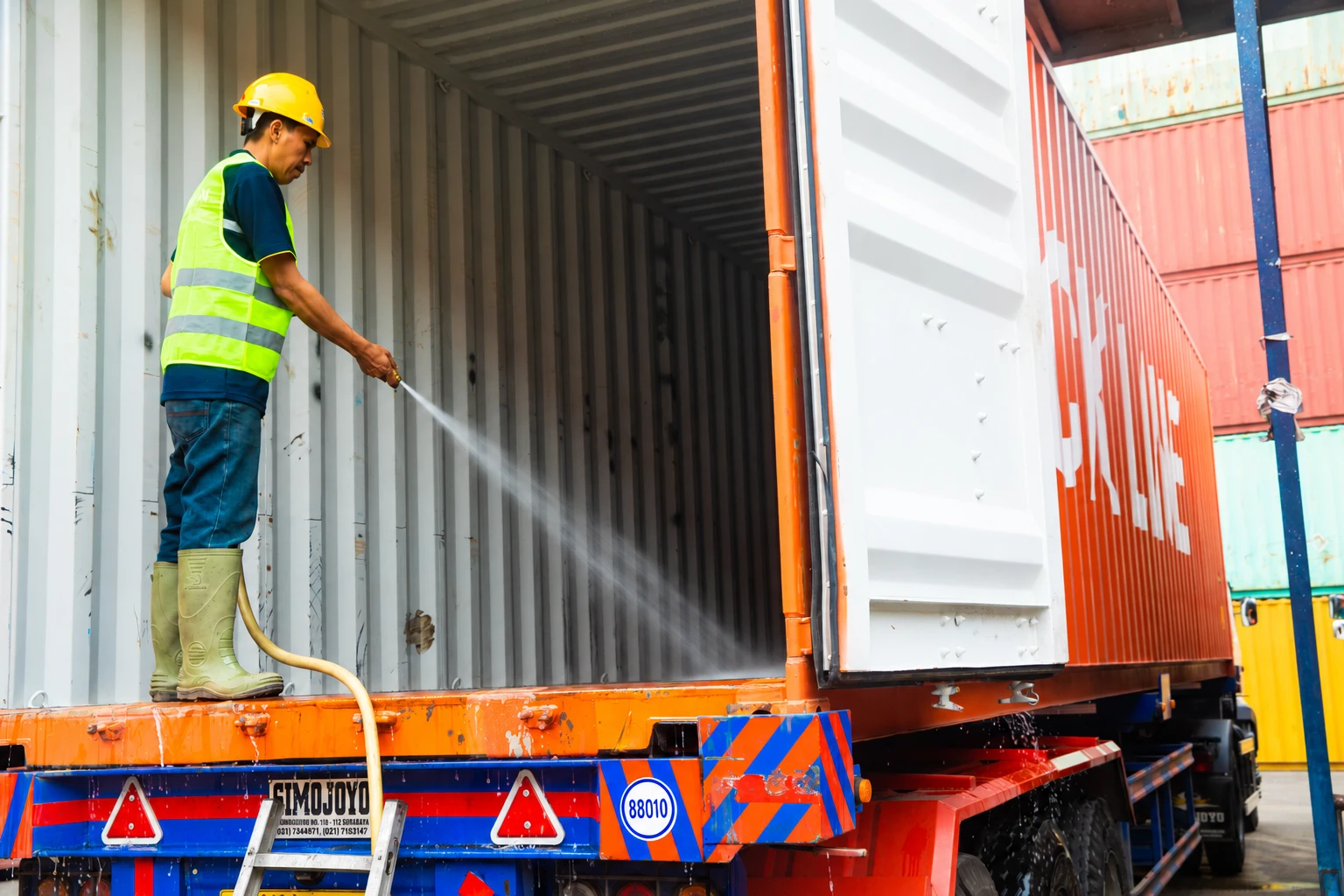 Worker washing the inside of a container